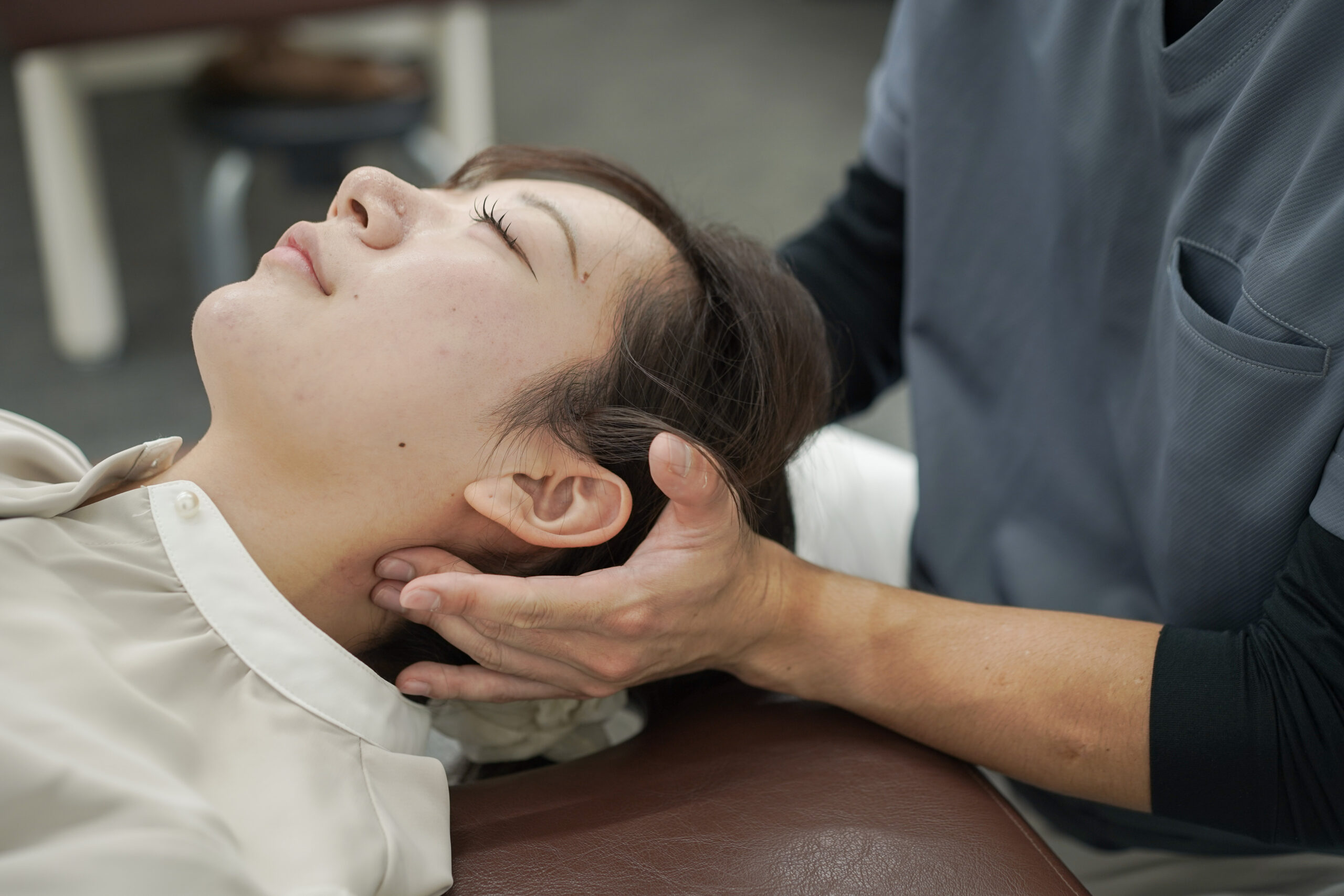 CUREPROで施術者が利用者の首まわりを丁寧に確認する様子