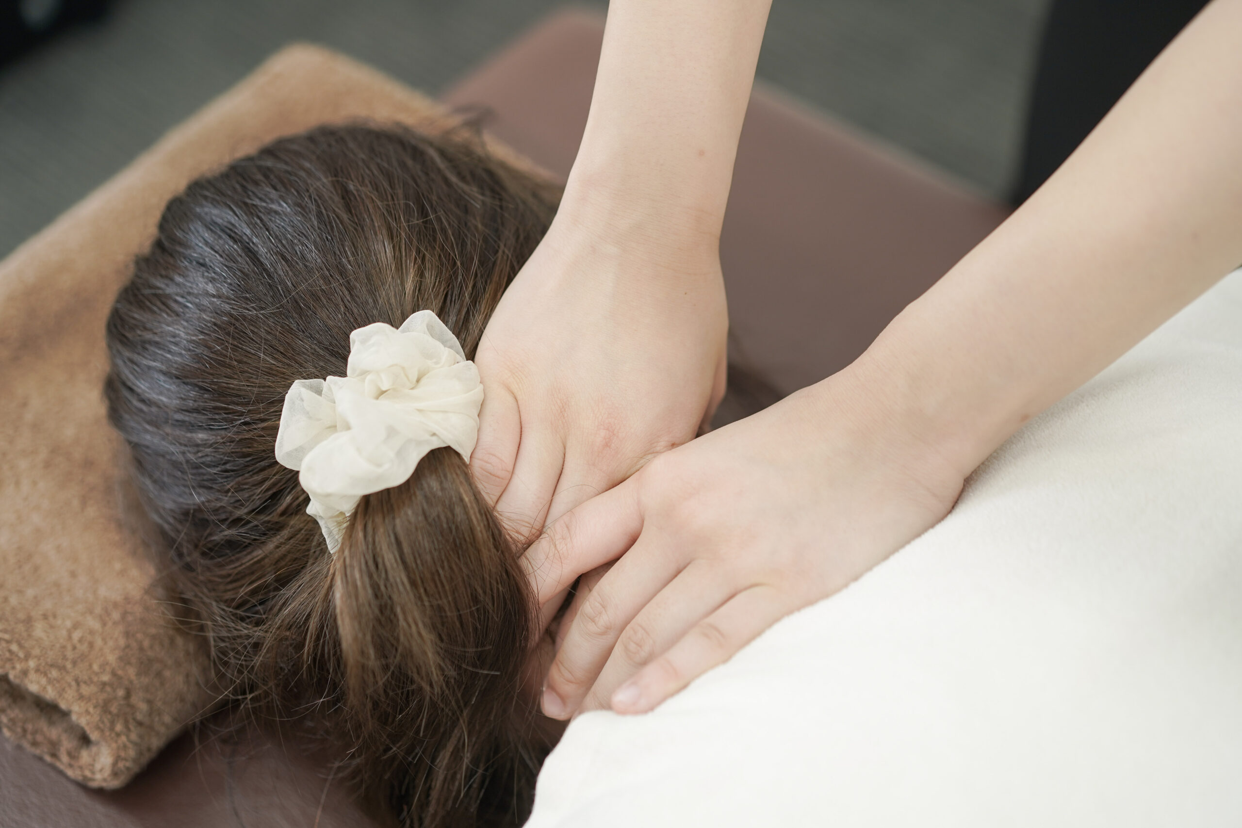 CUREPROで施術者が首まわりの状態を丁寧に確認する様子