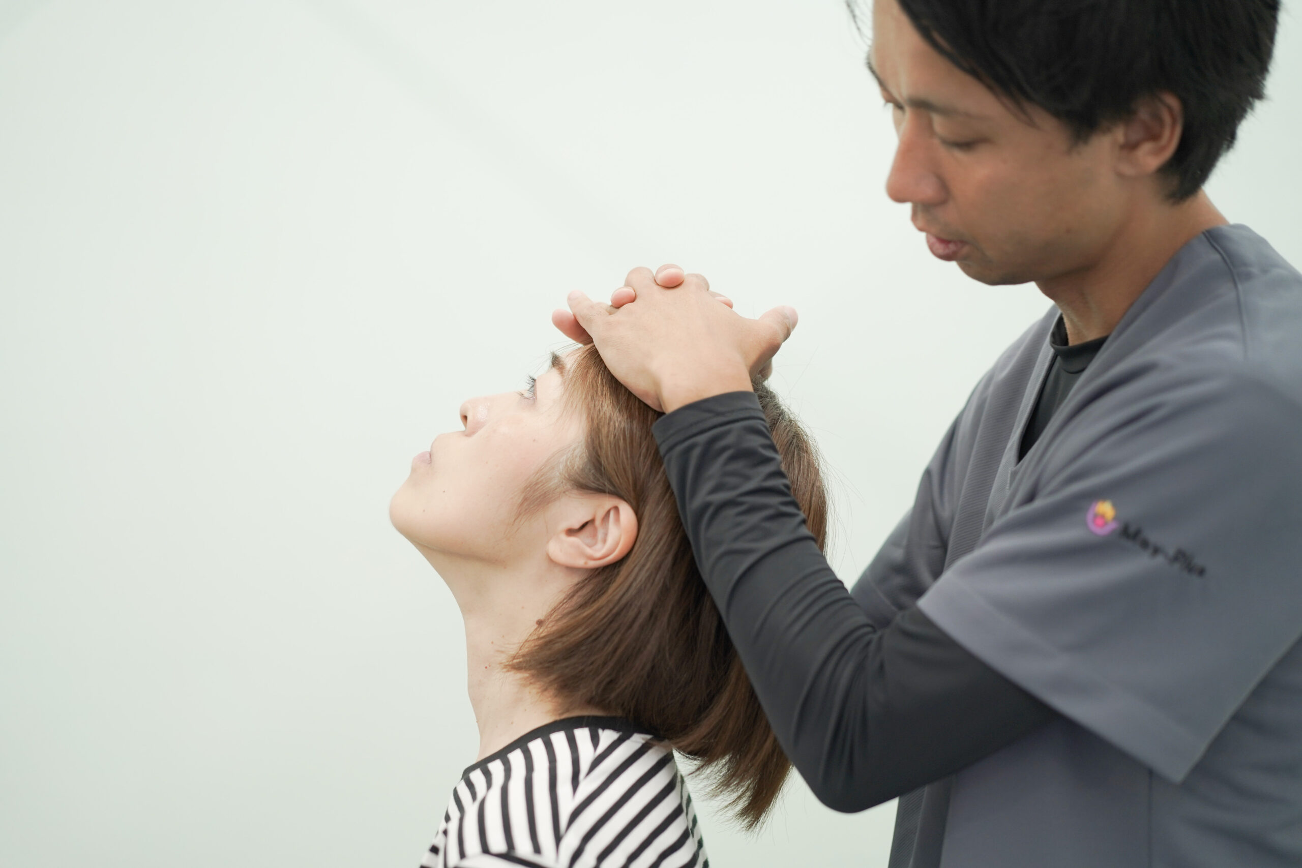 CUREPROで施術者が首まわりを丁寧に確認する様子